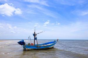 Traditional fishing boat floating on water, blue sea and sky photo