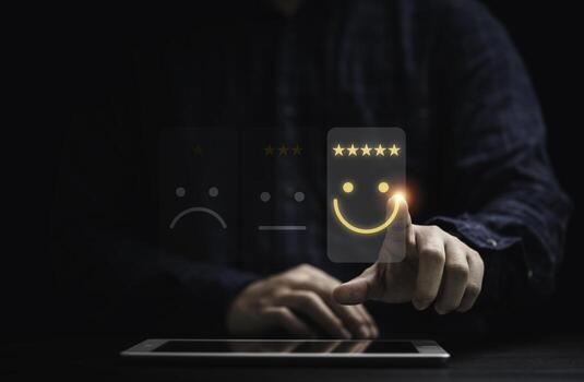 Businessman using smartphone for select smiley face icon for client evaluation and customer satisfaction after use product and service concept. photo