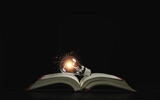 Lightbulb glowing on book over dark background for creative thinking idea after reading and study concept. photo