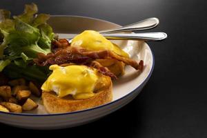 huevos benedicto tocino desayuno en la mesa foto