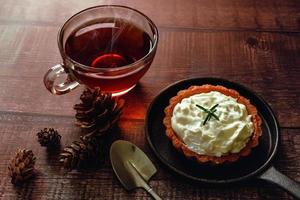 Apple tart with hot tea on wooden table photo