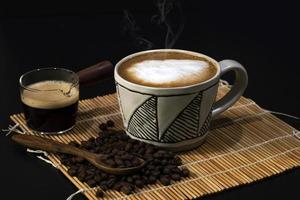 hot latte with coffee beans on dark background photo