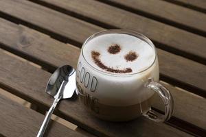 café con leche caliente con cara sonriente arte latte foto