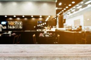 Wood table top on blur cafe restaurant with bokeh background photo