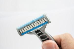 Hand with shaving razor isolated on a white background photo