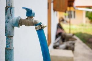 water tap with blue rubber tube photo