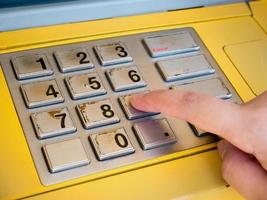 woman using ATM machine to withdraw money photo