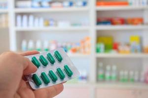 Close up of pharmacist hands holding medicine pills photo