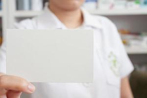 pharmacist holding blank paper in the pharmacy store photo