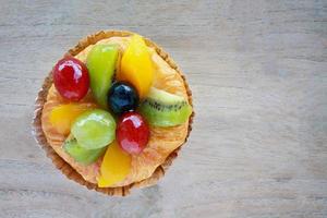 cerrar pastelería danesa con fruta en la mesa de madera foto