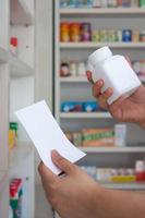 mano de farmacéutico con papel de prescripción en blanco en la farmacia