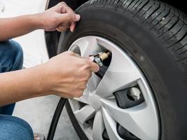 man filling air pressure in the car tyre photo