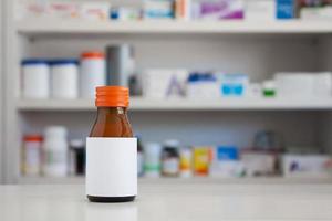 Blank white label of medicine bottle with blur shelves of drug in the pharmacy drugstore background photo