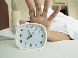 white alarm clock and sleeping man photo