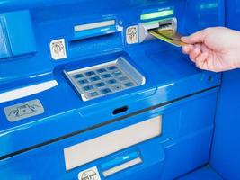 female hand inserting ATM card into ATM bank machine photo