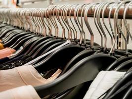 Clothes on hangers in clothing store photo