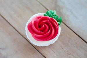 red rose cupcake on wooden table photo