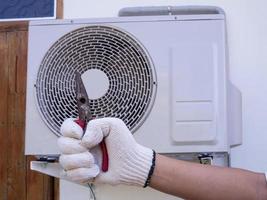 technician installing outdoor air conditioning unit photo