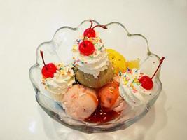 Ice cream scoops with whipped cream and cherry photo