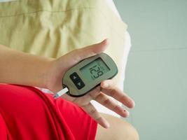 measuring glucose level with digital glucose meter photo