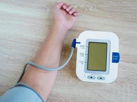 man using digital blood pressure monitor photo