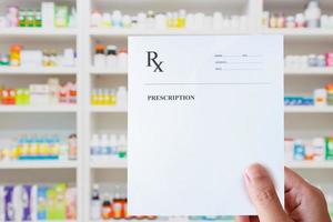 Farmacéutico mano sujetando prescripción rx papel en la mano foto