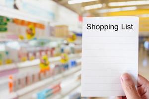 hand hold white paper over supermarket background photo