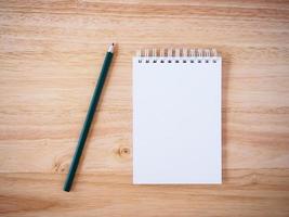 Pencil and Notepad on the wooden desk photo