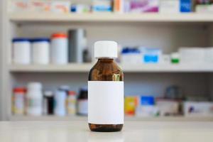 Blank white label of medicine bottle with blur shelves of drug in the pharmacy drugstore background photo