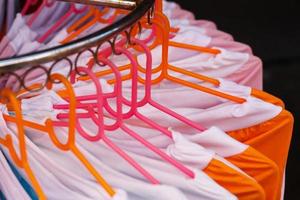 Choice of fashion clothes of different colors on hangers photo