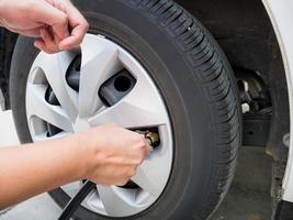 man filling air pressure in the car tyre photo