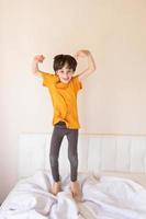 An energetic child is jumping on the bed photo