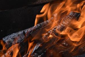 Blazing firewood in the fire coals photo