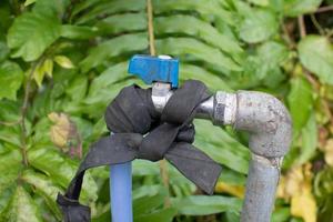 a water faucet connected to a hose and rolled up using black rubber photo