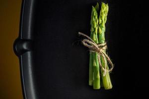 Asparagus. Bunch of fresh green asparagus tied on a frying pan. Healthy vegetarian food. Horizontal image