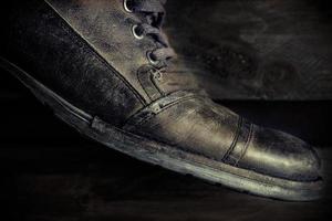 Detail of gray leather casual shoe for man on wooden board. Dark mood style. Horizontal image. photo