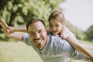 padre con hija divirtiéndose en el parque foto