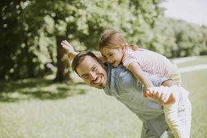 padre con hija divirtiéndose en el parque foto