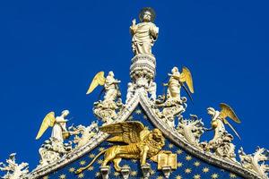 Marble statues on top of the Basilica and Cathedral of San Marco in Venice, Italy photo