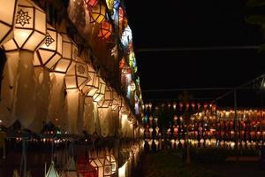 Linternas de papel bellamente formadas y coloridas se cuelgan frente a una pagoda para adorar al Señor Buda en un templo en el norte de Tailandia. foto