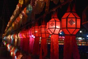 Beautifully shaped and colorful paper lanterns are hung in front of a pagoda to worship Lord Buddha in a temple in northern Thailand. photo