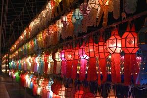 Beautifully shaped and colorful paper lanterns are hung in front of a pagoda to worship Lord Buddha in a temple in northern Thailand. photo