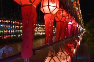 Beautifully shaped and colorful paper lanterns are hung in front of a pagoda to worship Lord Buddha in a temple in northern Thailand. photo