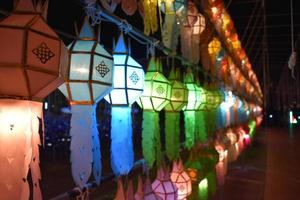 Beautifully shaped and colorful paper lanterns are hung in front of a pagoda to worship Lord Buddha in a temple in northern Thailand. photo
