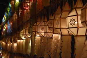 Beautifully shaped and colorful paper lanterns are hung in front of a pagoda to worship Lord Buddha in a temple in northern Thailand. photo