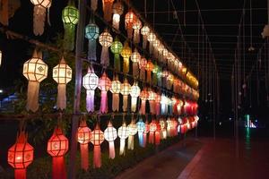 Beautifully shaped and colorful paper lanterns are hung in front of a pagoda to worship Lord Buddha in a temple in northern Thailand. photo
