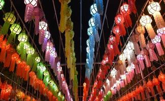 Beautifully shaped and colorful paper lanterns are hung in front of a pagoda to worship Lord Buddha in a temple in northern Thailand. photo