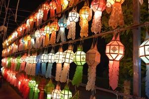 Beautifully shaped and colorful paper lanterns are hung in front of a pagoda to worship Lord Buddha in a temple in northern Thailand. photo