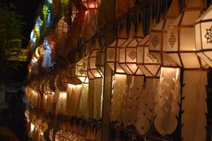 Beautifully shaped and colorful paper lanterns are hung in front of a pagoda to worship Lord Buddha in a temple in northern Thailand. photo