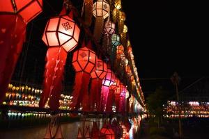 Beautifully shaped and colorful paper lanterns are hung in front of a pagoda to worship Lord Buddha in a temple in northern Thailand. photo